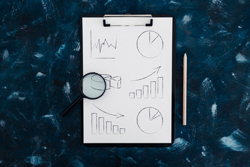 business analysis and statistics, desk with mixed graphs and charts on clipboard