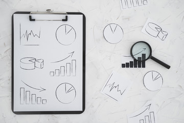 business analysis and statistics, desk with mixed graphs and charts on clipboard with magnifying...