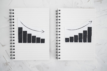 business analysis and statistics, positive and negative trends on graphs on notebooks