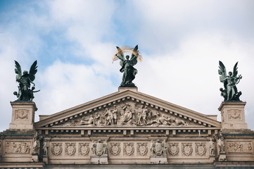 Fototapeta premium The roof of Lviv theatre of opera and ballet. The central sculpture is Glory, left one is Music, right figure is Comedy and Drama. Copy space.