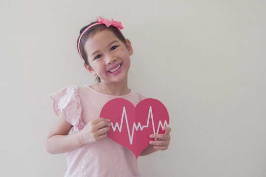 Mixed race child holding big red heart with cardiogram,  children health care, life insurance business concept, world heart day, world health day - Powered by Adobe
