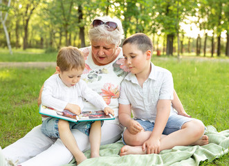 Senior woman playing with grandchildren outdoor. Granny with grandsons