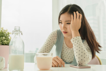 Young beautiful pregnant asian thai woman feel depression and headache at home after breakfast.