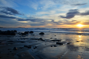 The Moeraki Boulders are unusually large and spherical boulders lying along a stretch of Koekohe Beach on the wave-cut Otago coast of New Zealand.