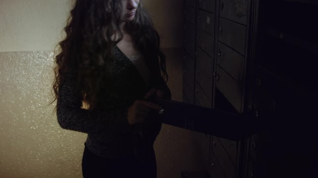Young caucasian woman checks a mailbox at home.
