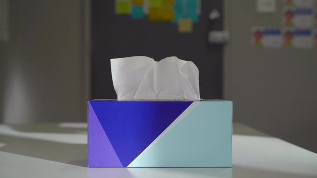 Hand taking multiple tissues from a tissue box