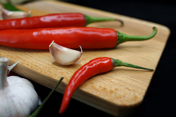 Fresh Red Chilies And Garlic On Wooden Cutting Board