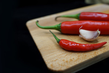 Fresh Red Chilies And Garlic On Wooden Cutting Board