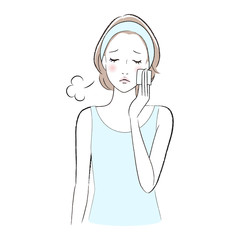 コットンで化粧水をパッティングしながらため息をつく女性