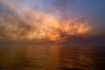 Sea sunset. Smoke wildfires sweeping across the sky.