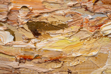 Macro. Abstract art. Expressive embossed pasty oil paints and reliefs. Colors: yellow, white, ocher, brown.