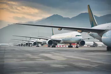 Foto auf Leinwand Aufgrund von Coronavirus Covid-19 ist die Flotte der Fluggesellschaft auf dem Rollweg des Flughafens geparkt © heychli