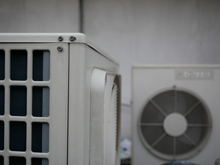 closeup of air conditioner compressor outside building.