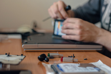 Male technician fixing broken laptop at home, closeup photo