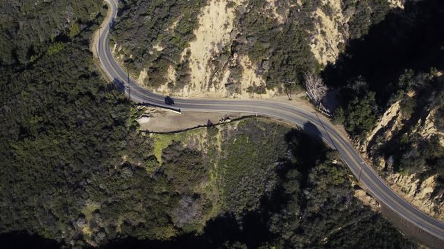 Drone flying with black car driving in California canyon