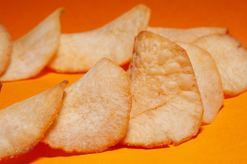 Delicious potato chips isolated on orange gradiated background