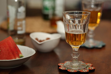 glass of beer on table, pieces of watermelon, bottle, snack