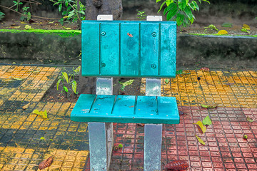 A blue painted chair placed in a park for sitting of a single person