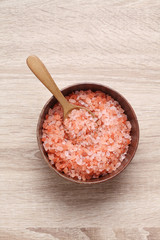 Himalayan pink salt in wooden cup on wooden table
