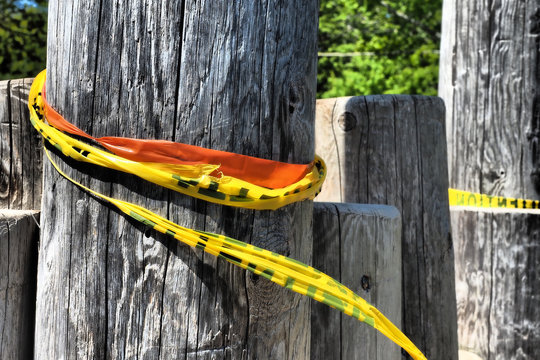 Closeup Of Caution Tape Wrapped Around A Log