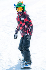 Fototapeta na wymiar Cute Boy Having Fun, Snowboarding in the Mountains
