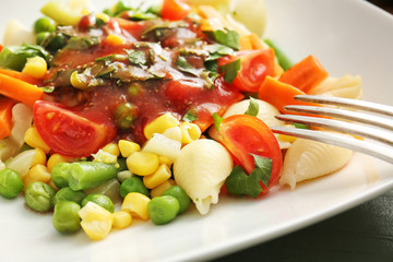 Plate with tasty conchiglie pasta and vegetables, closeup