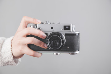 Girl holding a retro camera in office.