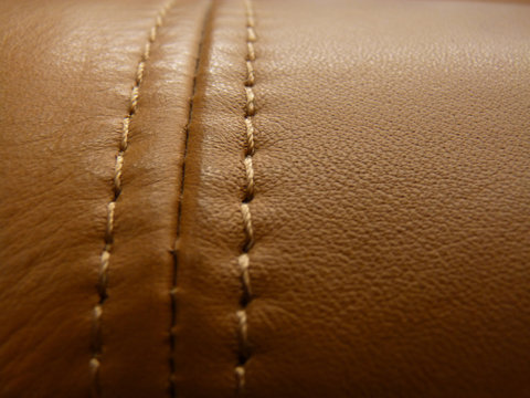 Closeup of an expensive leather sofa stitched with brown thread