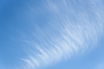 Wispy white clouds against a blue sky as a nature background
