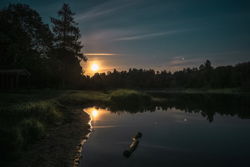 Night landscape with the reflection of the moon in the lake
