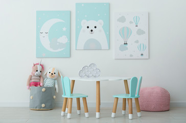 Adorable wall art, table and chairs with bunny ears in children's room interior