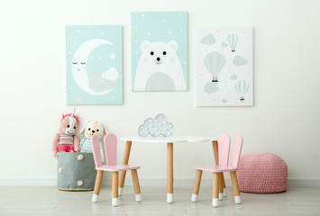 Adorable wall art, table and chairs with bunny ears in children's room interior
