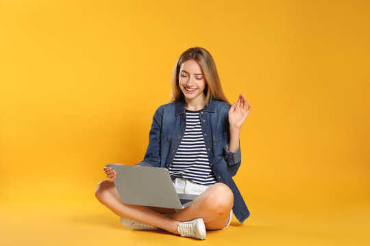 Young Woman With Laptop On Yellow Background