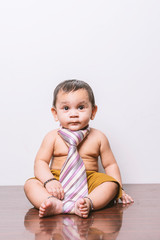 Naklejka premium Baby in-front of white wall playing with red pillow.
