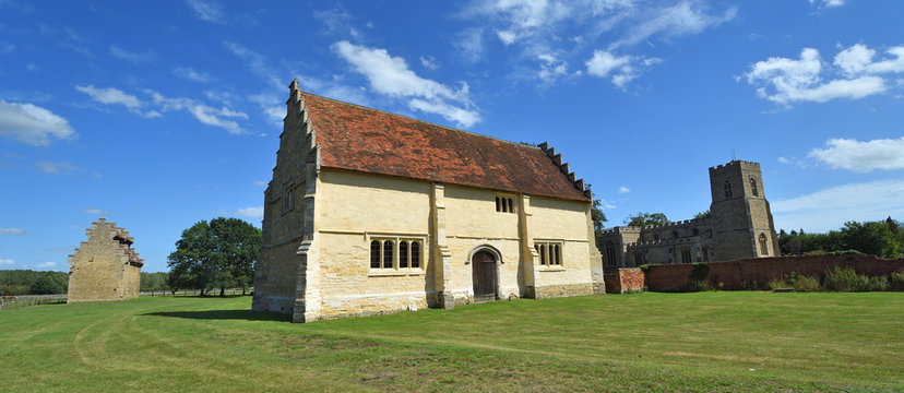 Willington  Church, stables and Dovecote on a sunny day with blue sky and clouds.