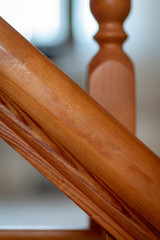 Element of a wooden interior staircase. Wooden baluster close-up.