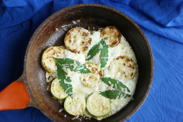 cannabis food. classic cannabis leaf lies on a fried egg baked with zucchini and marijuana leaves. grated cheese sprinkled on top.