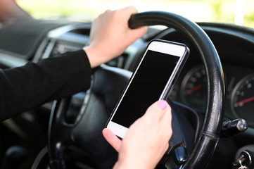 Woman using mobile phone while driving a vehicle