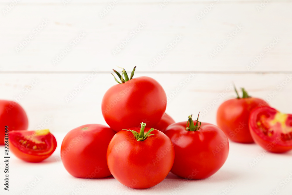 Wall mural Ripe red tomatoes on a white wooden background