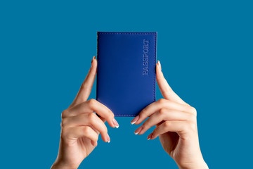 Passport service. Visa center. Female hands holding national id book in blue cover isolated on...