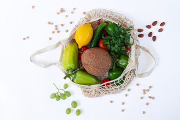 Mesh shopping grocery bag full of healthy food on white background top view