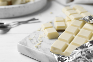 Tasty white chocolate on wooden table, closeup