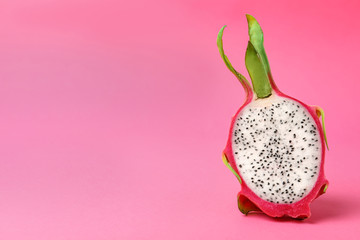 Half of delicious ripe dragon fruit (pitahaya) on pink background. Space for text