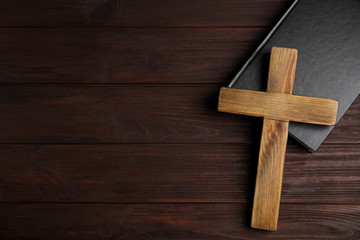 Naklejka na ściany i meble Christian cross and Bible on wooden background, top view with space for text. Religion concept