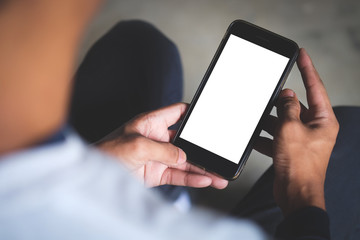 Cropped shot view of man hands holding smart phone with blank copy space screen for your text message or information content, female reading text message on cell telephone during in urban setting. 