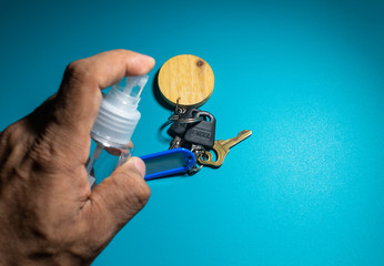 cleaning keys with sanitizer to prevent from corona virus, covid 19