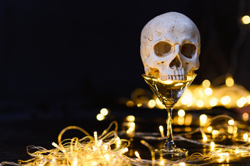 human skull on empty drink glass and LED lights decoration with free copy space for text. decor for...