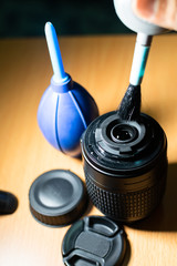 cleaning camera lens with hand blower and brush