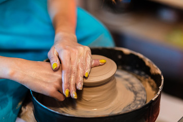 woman potter hands makes on the pottery wheel clay pot, close up. Potter's wheel. Pottery concept. - 372846011
