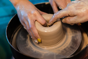 Creating a clay jar or vase. Workshop on modeling clay on pottery wheels in a pottery workshop. The sculptor in the workshop makes a jug out of earthenware closeup. - 372846043